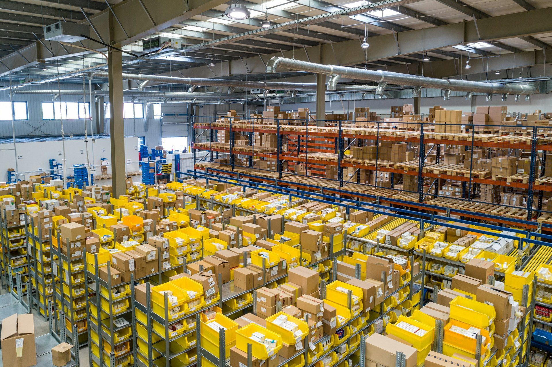 Warehouse interior with tall pallet racks and stacks of boxed inventory