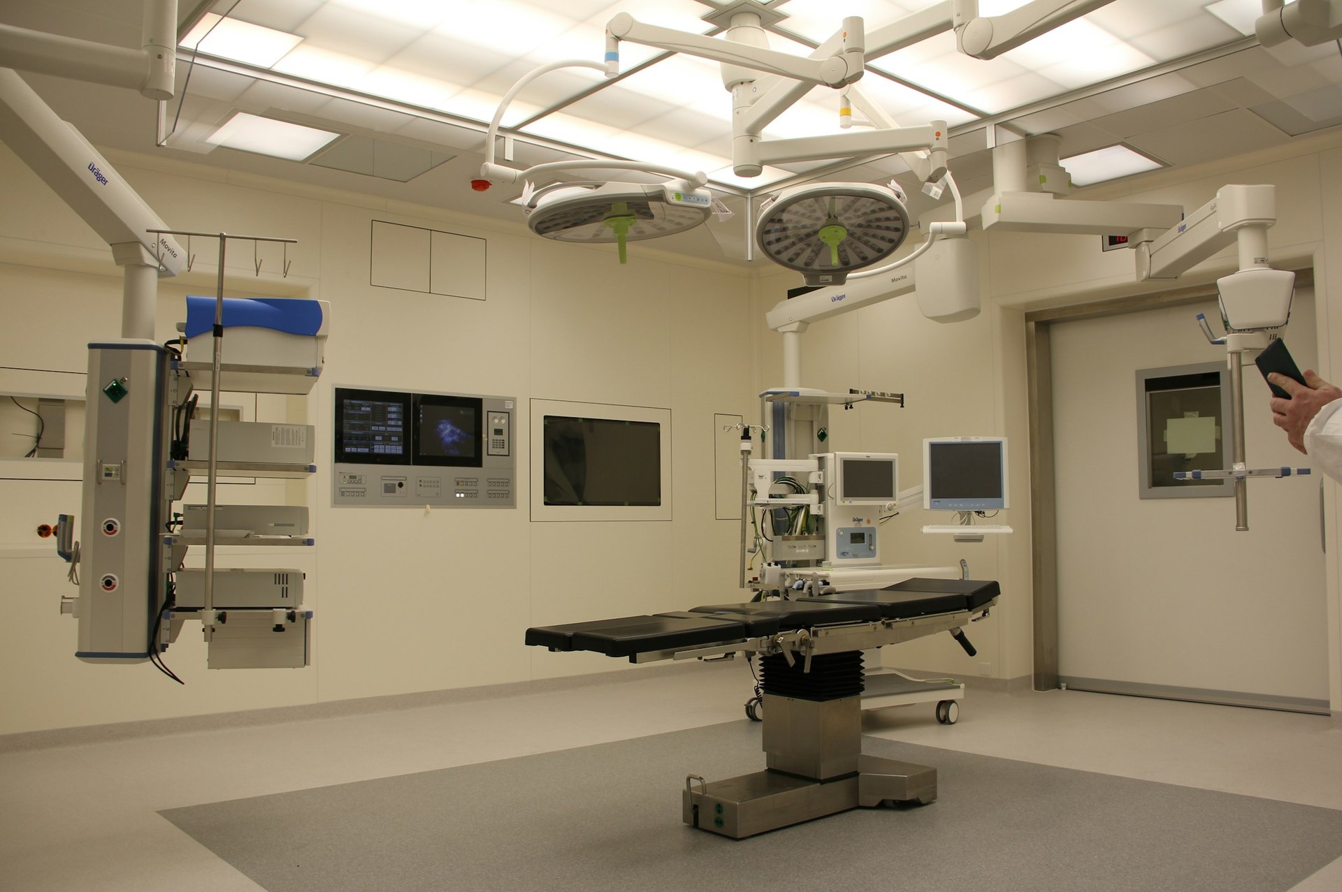 Medical procedure room with a treatment table, overhead lights and wall mounted equipment